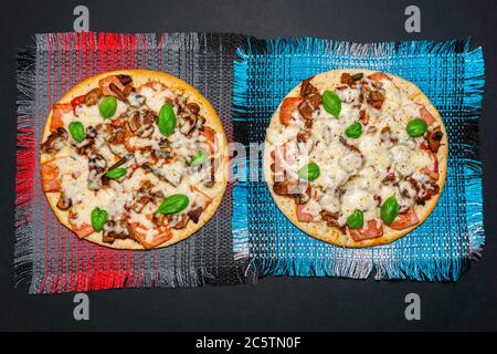 Deux pizzas aux champignons, au jambon et au basilic sur fond noir. Copier l'espace. Vue du dessus. flat lay Banque D'Images