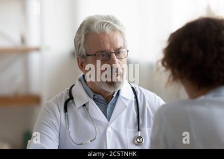 Un médecin de sexe masculin senior consulte le patient lors de la réunion Banque D'Images