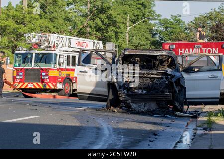 Pompiers de véhicule qui mettent feu dans la rue. Vus brûlé avec service d'incendie contenant la propagation du feu. Incendie de voiture de jour - gros plan 911 Banque D'Images