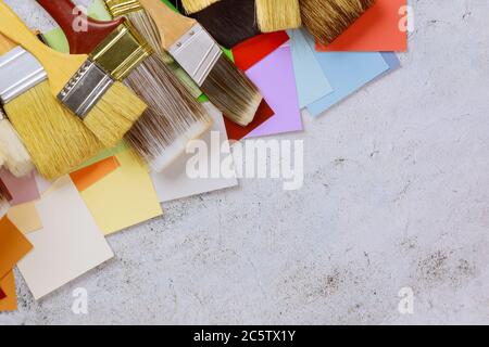 Outils de peinture accessoires pour la rénovation à la maison avec palette de choix de couleurs et divers outils de pinceau sur la table en bois Banque D'Images