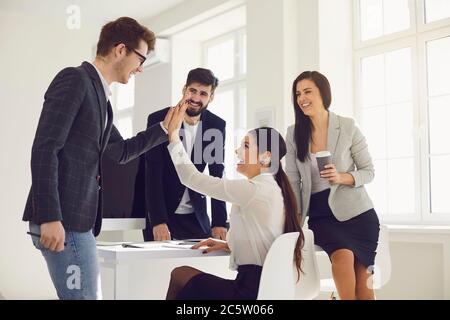 Les gens d'affaires heureux donnent de nouvelles idées pour un nouveau projet de démarrage lors d'une réunion au bureau. Banque D'Images