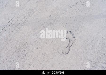 Texture de fond d'une trace de pieds et de pneus sur l'asphalte. Gros plan. Texture des pneus de voiture et empreinte d'une personne. Empreintes d'un homme Banque D'Images