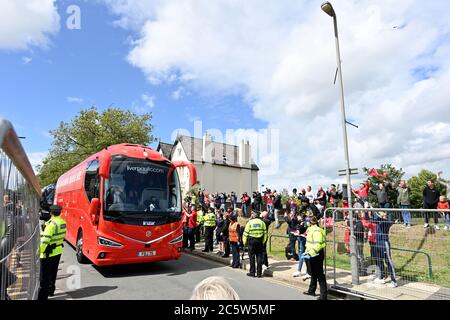 Les fans se trouvent à l'extérieur du sol, tandis que le bus de l'équipe de Liverpool arrive à Anfield avant le match de la Premier League à Anfield, Liverpool. Banque D'Images