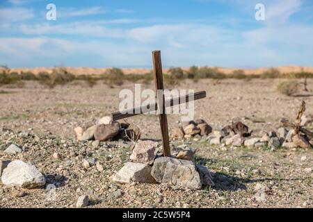 Une croix sur une tombe non marquée, dans un petit cimetière en bord de route près des dunes de sable impériales, Californie Banque D'Images