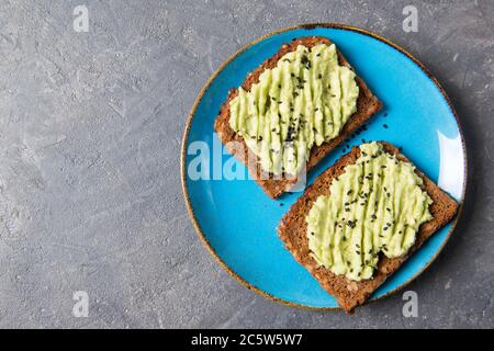 Toasts d'avocat sur du pain de grain entier, purée d'avocat avec des graines de sésame, concept de saine alimentation, vue du dessus Banque D'Images