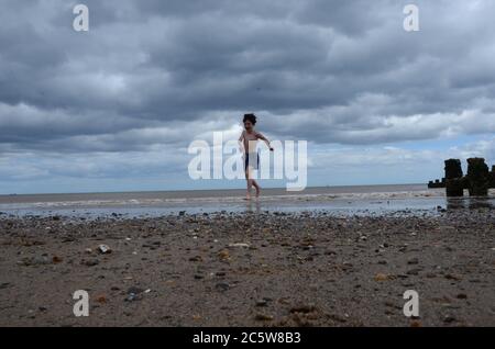 Garçon jouant dans la mer, Hornsea, Banque D'Images