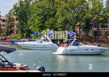 Mooresville, NC, USA - 4 juillet 2020 : des bateaux battant le drapeau de Trump 2020 pour le président Donald Trump sur le lac Norman près du club de golf national de Trump Banque D'Images