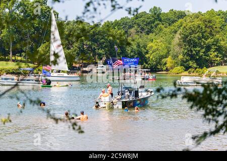 Mooresville, NC, USA - 4 juillet 2020 : des bateaux battant le drapeau de Trump 2020 pour le président Donald Trump sur le lac Norman près du club de golf national de Trump Banque D'Images