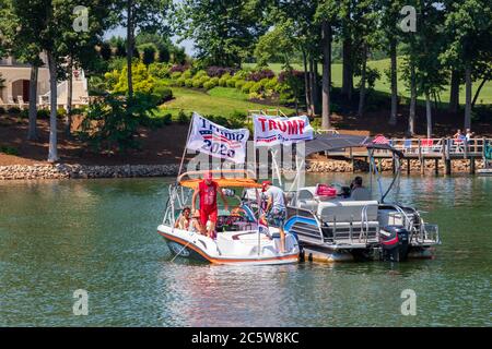 Mooresville, NC, USA - 4 juillet 2020 : des bateaux battant le drapeau de Trump 2020 pour le président Donald Trump sur le lac Norman près du club de golf national de Trump Banque D'Images