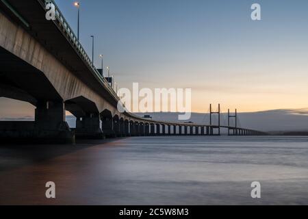 Le deuxième pont Severn Crossing qui transporte l'autoroute M4 entre l'Angleterre et le pays de Galles est éclairé au crépuscule par les feux de circulation et les sentiers de passage. Banque D'Images