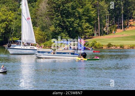 Mooresville, NC, USA - 4 juillet 2020 : des bateaux battant le drapeau de Trump 2020 pour le président Donald Trump sur le lac Norman près du club de golf national de Trump Banque D'Images