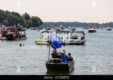 Mooresville, NC, USA - 4 juillet 2020 : des bateaux battant le drapeau de Trump 2020 pour le président Donald Trump sur le lac Norman près du club de golf national de Trump Banque D'Images