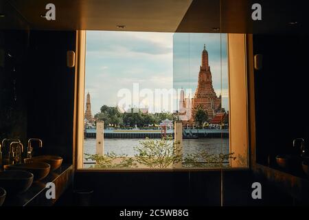 BANGKOK, THAÏLANDE - JUL 5, 2020: Le paysage de Wat Arun (Temple de l'Aube) depuis la fenêtre d'un restaurant au coucher du soleil Banque D'Images