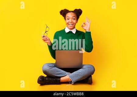 Joyeux adolescent afro montrant le signe ok geste Banque D'Images