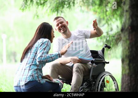 Homme handicapé homme avec petite amie souriant sur le portrait de marche du parc Banque D'Images