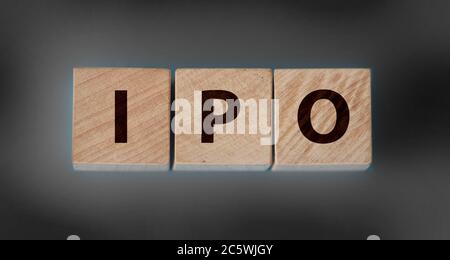 IPO, initial public offrande pour la société à acheter et vendre en bourse, bloc de cube en bois avec alphabet construisant le mot IPO sur table en bois, sombre Banque D'Images