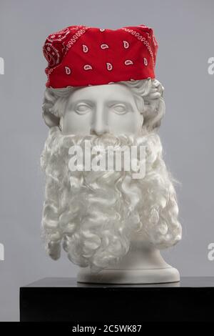 Statue en plâtre blanc d'un buste d'Apollo Belvedere avec une longue barbe blanche et un foulard de bandana rouge Banque D'Images