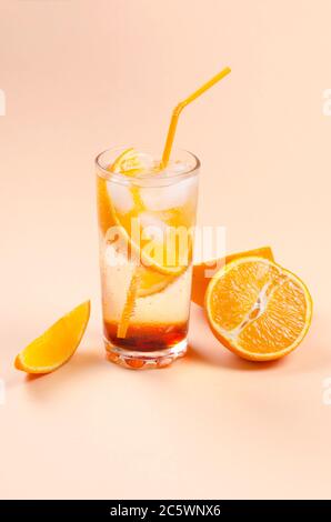 Cocktail d'alcool orange avec tranche de fruits orange sur fond jaune Banque D'Images