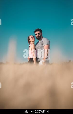 Jeune couple qui embrasse dans le champ de blé en été Banque D'Images