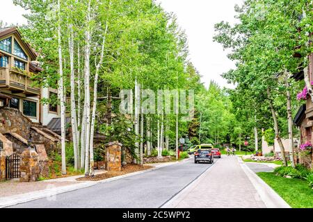 Vail, USA - 29 juin 2019: Station de ski de la ville du Colorado avec des voitures et des gens sur la route par les arbres d'aspen et l'architecture moderne des immeubles d'appartements Banque D'Images