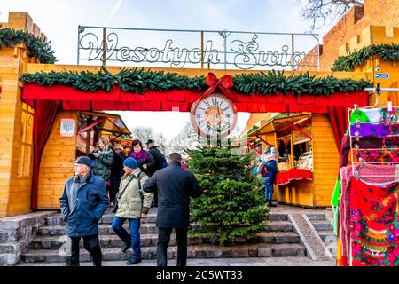 Varsovie, Pologne - 19 décembre 2019: Vieille ville de Varsovie pendant la journée avec marché de Noël près de la place du château royal personnes marchant par l'entrée avec l'horloge Banque D'Images