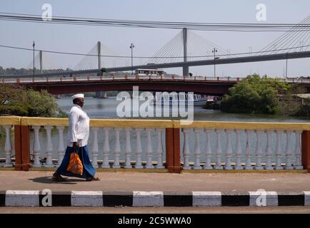 Homme local marchant sur l'ancien pont Patto, ruisseau Ourem, Panajim, Goa, Inde. Banque D'Images