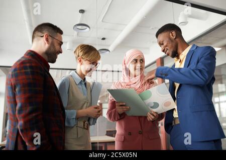 Portrait de l'équipe multiethnique contemporaine discutant d'un projet professionnel au bureau, concentrez-vous sur une femme d'affaires musulmane qui parle à ses collègues Banque D'Images