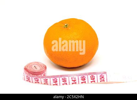 Orange fruit et tailleurs centimètre sur fond blanc. Photo conceptuelle du combat de cellulite et de l'amincissement du régime. Contrôle nutritionnel de forme d'été. Poids bas Banque D'Images