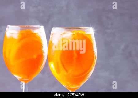 Cocktail apéritif Spritz sur fond gris. Deux verres d'aperol spritz avec des lamelles d'orange. Cocktail d'été en verre. Copier l'espace Banque D'Images