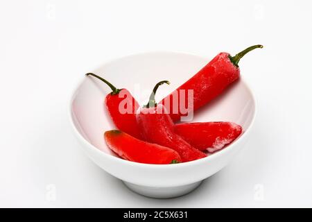 Bol de poivrons rouges congelés dans un bol chaud et froid concept Banque D'Images