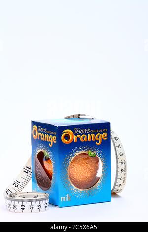 L'orange chocolat TerryS fabriqué par la carambar et co avec un mètre ruban peut être utilisé pour réduire la taille des produits ou des calories avec l'espace de copie Banque D'Images