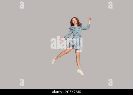 Happy Delicate girl en robe à volants vintage, avec danse de ballet, planant en plein air et souriant joyeusement, sautant le trampoline, se volant Banque D'Images