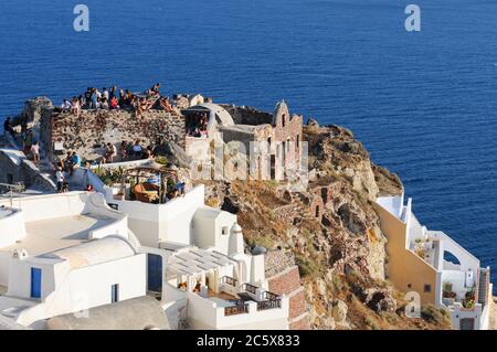 Touristes sur le toit d'une maison traditionnelle attendant le coucher de soleil étonnant à Santorin, île grecque, Grèce Banque D'Images