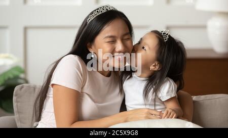 Petite drôle vietnamienne d'origine ethnique enfant fille embrassant maman. Banque D'Images