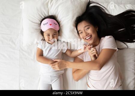 Sourire enfant asiatique s'amuser avec maman le matin. Banque D'Images