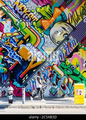 Street art à Brooklyn. Hipster homme marchant à côté d'un mur de graffiti à Brooklyn, New York, États-Unis. Banque D'Images