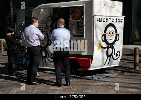 Salarymen pendant le déjeuner dans une rue du quartier commercial de Marunouchi faisant la queue dans un camion de rue. Tokyo, Japon. Banque D'Images