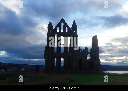 Le soleil commence à se coucher derrière un ciel nuageux à Whitby, dans le North Yorkshire Banque D'Images