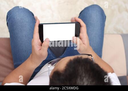 Homme joue sur le smartphone gestuelle, vide blanc écran téléphone maquette modèle, vue de dessus Banque D'Images