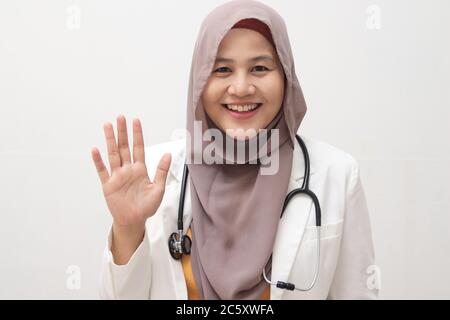 Belle jeune asiatique musulmane femme médecin femme utilisant le stéthoscope sur fond blanc isolé. En vous saluant, vous êtes heureux et souriant, et c'est sympa Banque D'Images