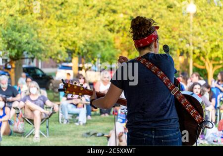 McGowan Park Summer concerts - Sandy Stones Trio Band - Femme jouant de la guitare devant la foule dans le parc public Banque D'Images