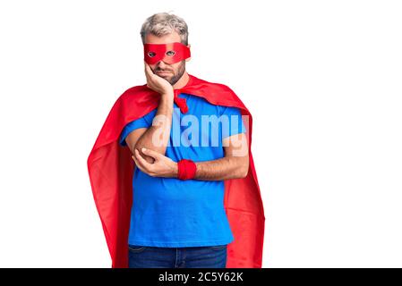 Jeune homme blond portant le super héros crème pensant fatigué et ennuyé avec des problèmes de dépression avec les bras croisés. Banque D'Images