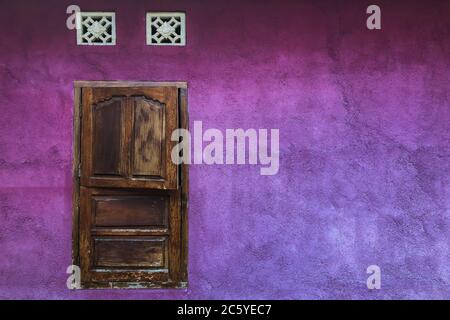 Mur de merde violet vif avec volets en bois fermés. Architecture colorée, style ancien et vintage. Emplacement vide pour le texte. Banque D'Images