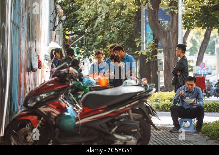 Saigon, Vietnam - 4 juillet 2020: Les rues de Saigon (Ho Chi min City), scène de personnes prenant le petit déjeuner sur le trottoir d'un chariot transportant de la nourriture. Banque D'Images