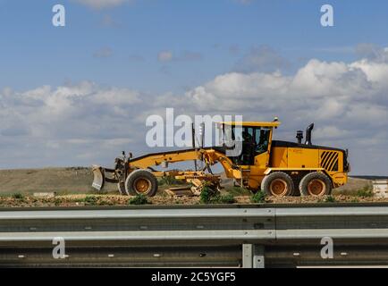 Niveleuse jaune. Construction de routes de niveleuse, machine industrielle pour la construction de nouvelles routes. Banque D'Images