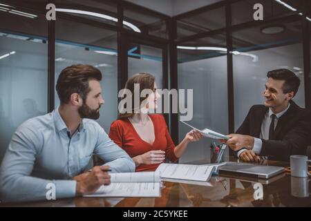 Agent de vente donnant un contrat à un couple Banque D'Images