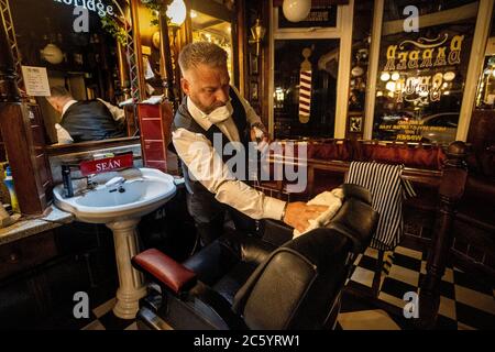 Sean Lawlor, copropriétaire de Cambridge Barbershop sur Lisburn Road à Belfast, se prépare à ouvrir à 00 h 01, alors que les coiffeurs et les salons de beauté rouvrent en Irlande du Nord, dans le cadre de la dernière mesure visant à atténuer les restrictions relatives aux coronavirus. Banque D'Images