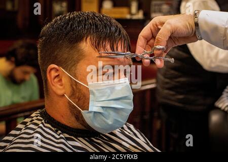 Damian Gilvary lors d'une coupe de cheveux à Cambridge Barbershop sur Lisburn Road de Belfast, qui a ouvert à 00 h 01, alors que les coiffeurs et salons de beauté rouvrent en Irlande du Nord, une partie de la dernière mesure pour atténuer les restrictions de coronavirus. Banque D'Images