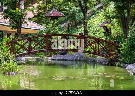 Pont voûté à travers un étang décoratif sur un jardin tropical japonais à Danang, Vietnam. Concept de voyage et de nature Banque D'Images