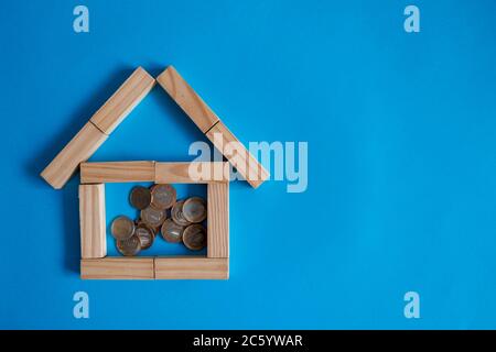 Gros plan de pièces avec le modèle Home sur une table en bois contre fond bleu. Banque D'Images